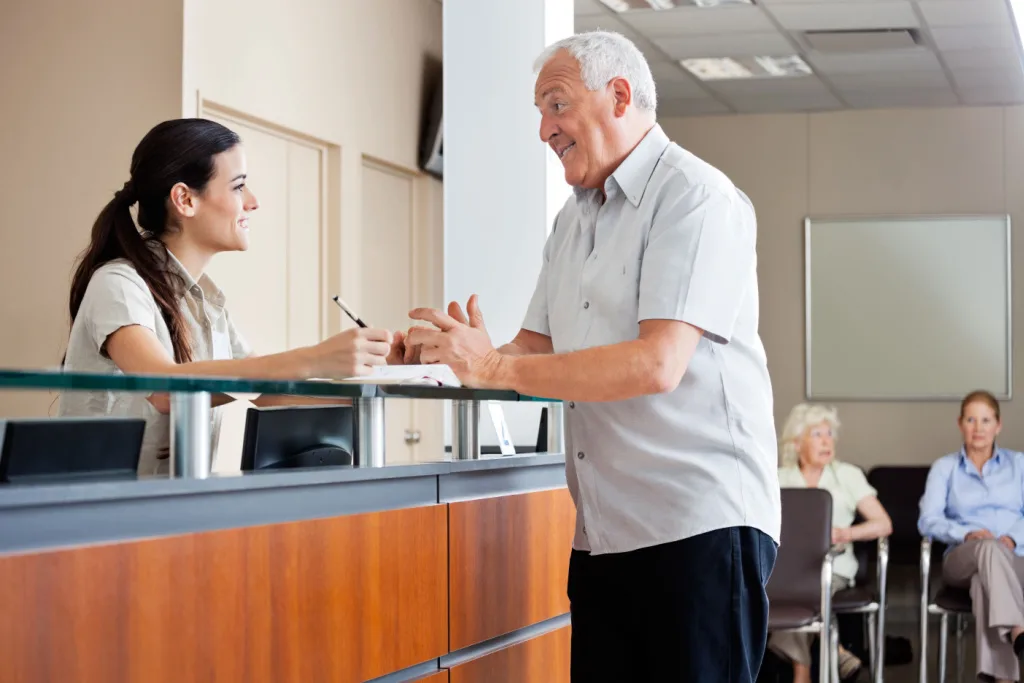 man at reception desk of hearing center